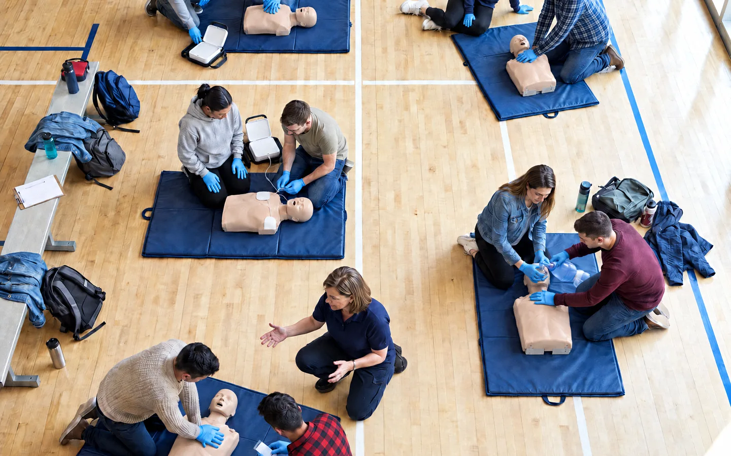 Pairs practising CPR together on a training floor